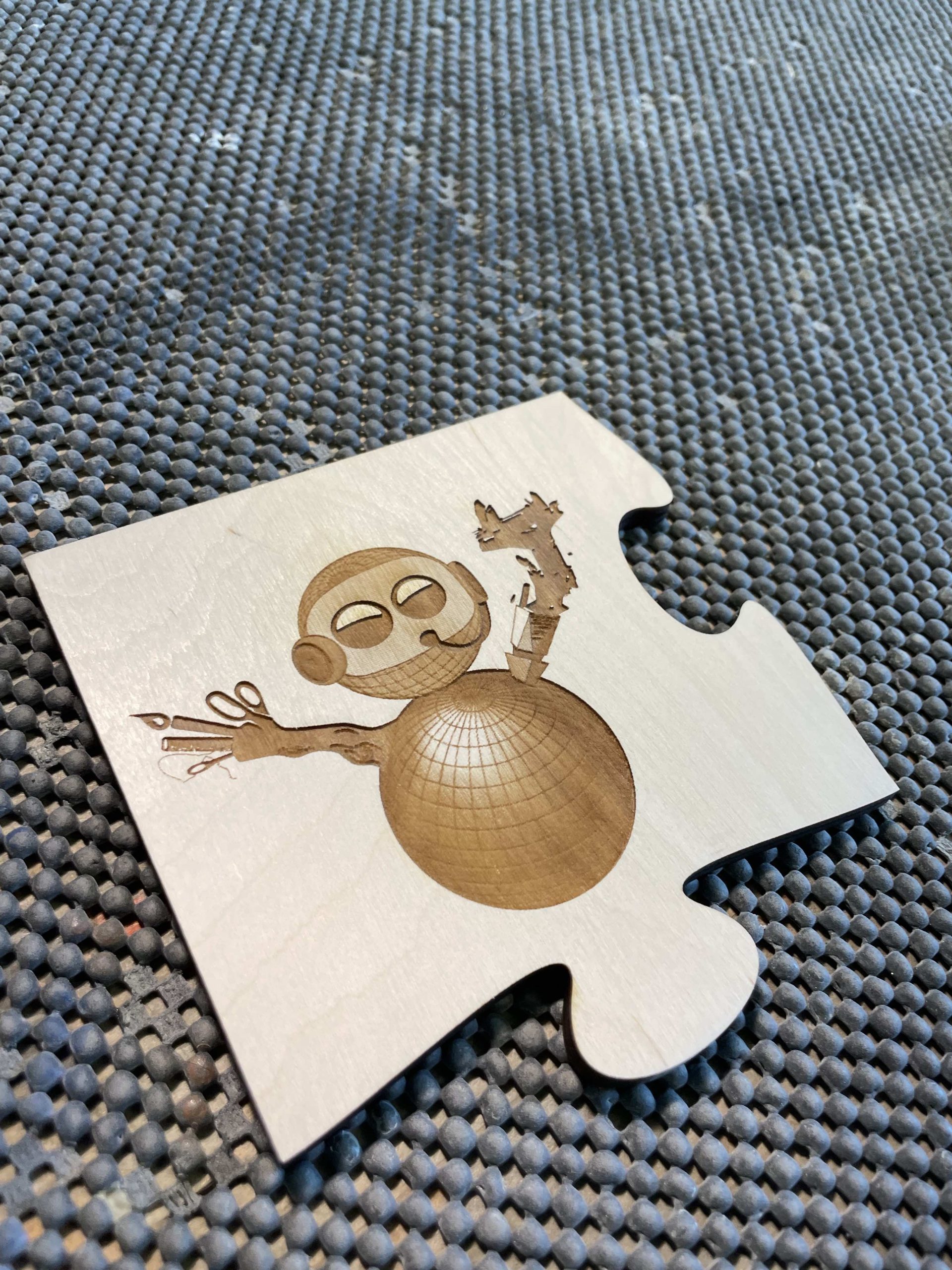 Art of MRC (pronounced Mercy) Robot cut into wood puzzle pieces by the IMRC Center Universal Laser