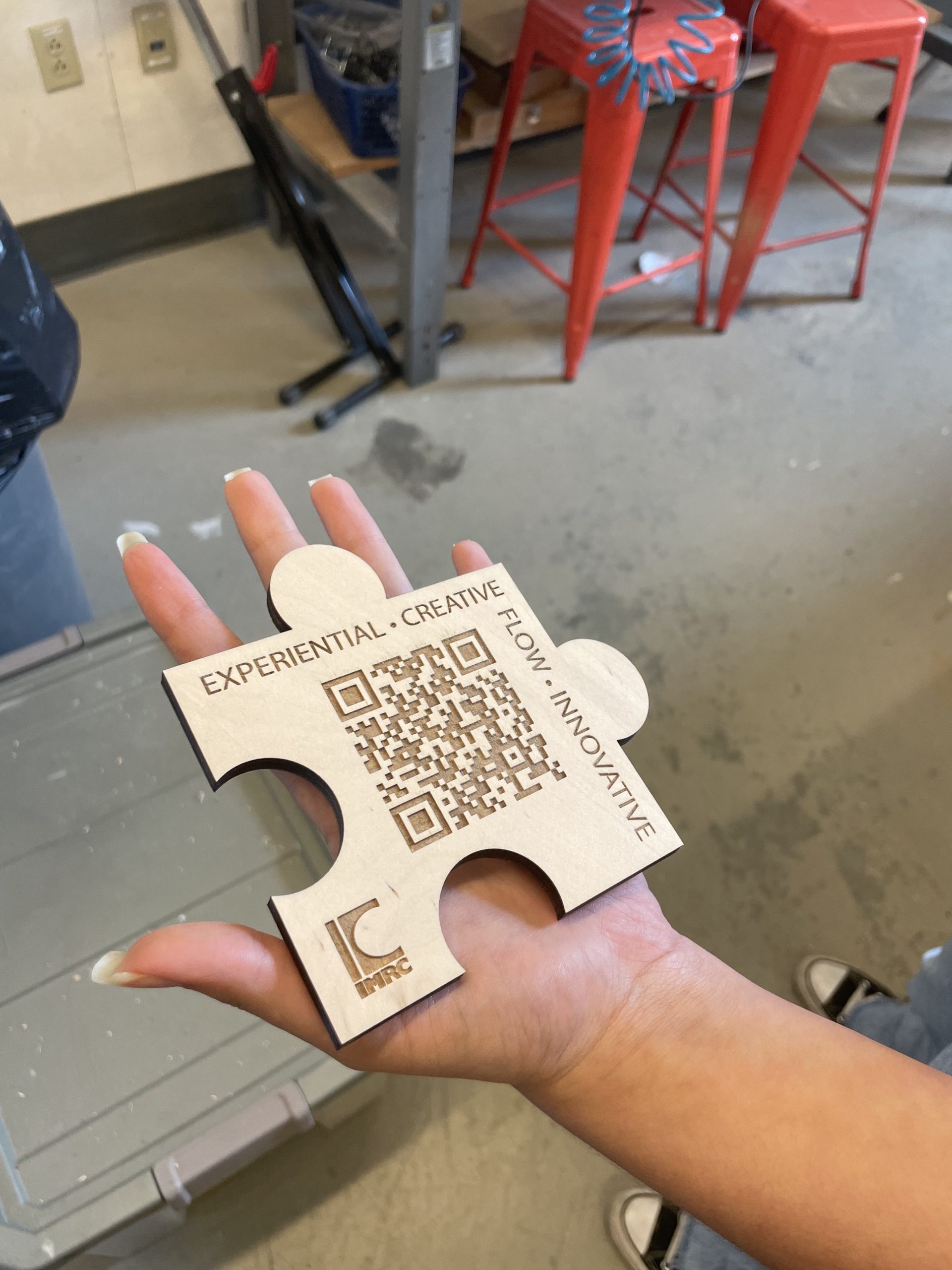 QR Code for IMRC Center and IMRC Center logo cut into wood puzzle pieces by the IMRC Center Universal Laser